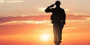 saluting soldier against sunset