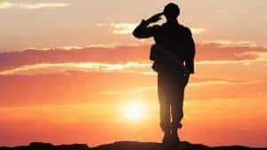 saluting soldier against sunset