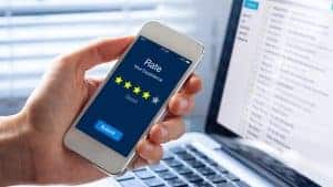 Hand holding a phone with a 4 star rating on the screen