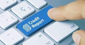 finger pressing computer button that says credit report