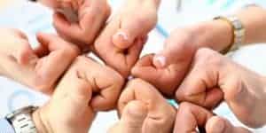 group of business people’s hands gathered together with thumbs up