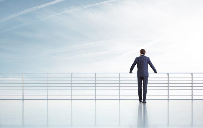 Businessman standing on a roof and looking sky
