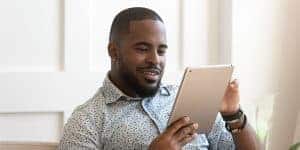 smiling man looking at tablet