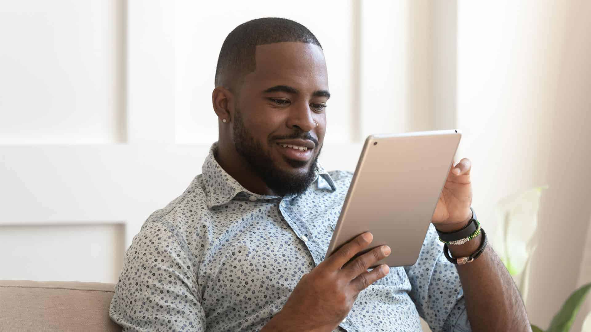 smiling man looking at tablet