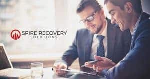 This is a spire recovery solutions logo where 2 working professionals working on the same tab with a smile on their face