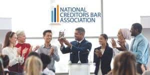 A group of professionals applauding for a recognition which they got from the national creditors bar association