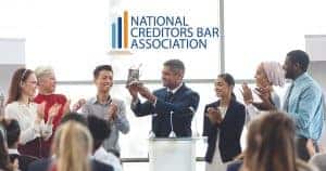 A group of professionals applauding for a recognition which they got from the national creditors bar association