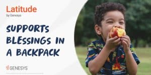 A little boy is outside and happily eating an apple.