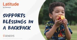 A little boy is outside and happily eating an apple.