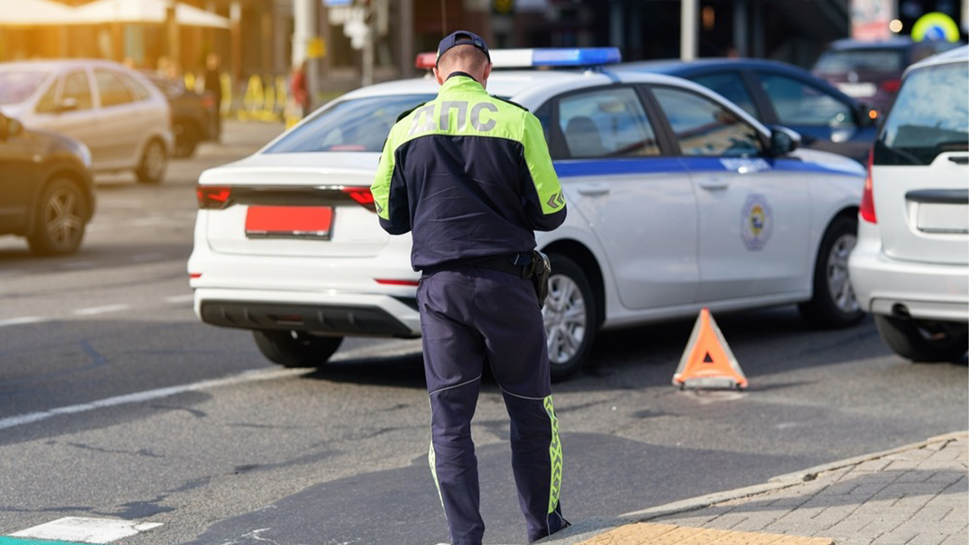 Road traffic inspector examines car crash site with damaged vehicle