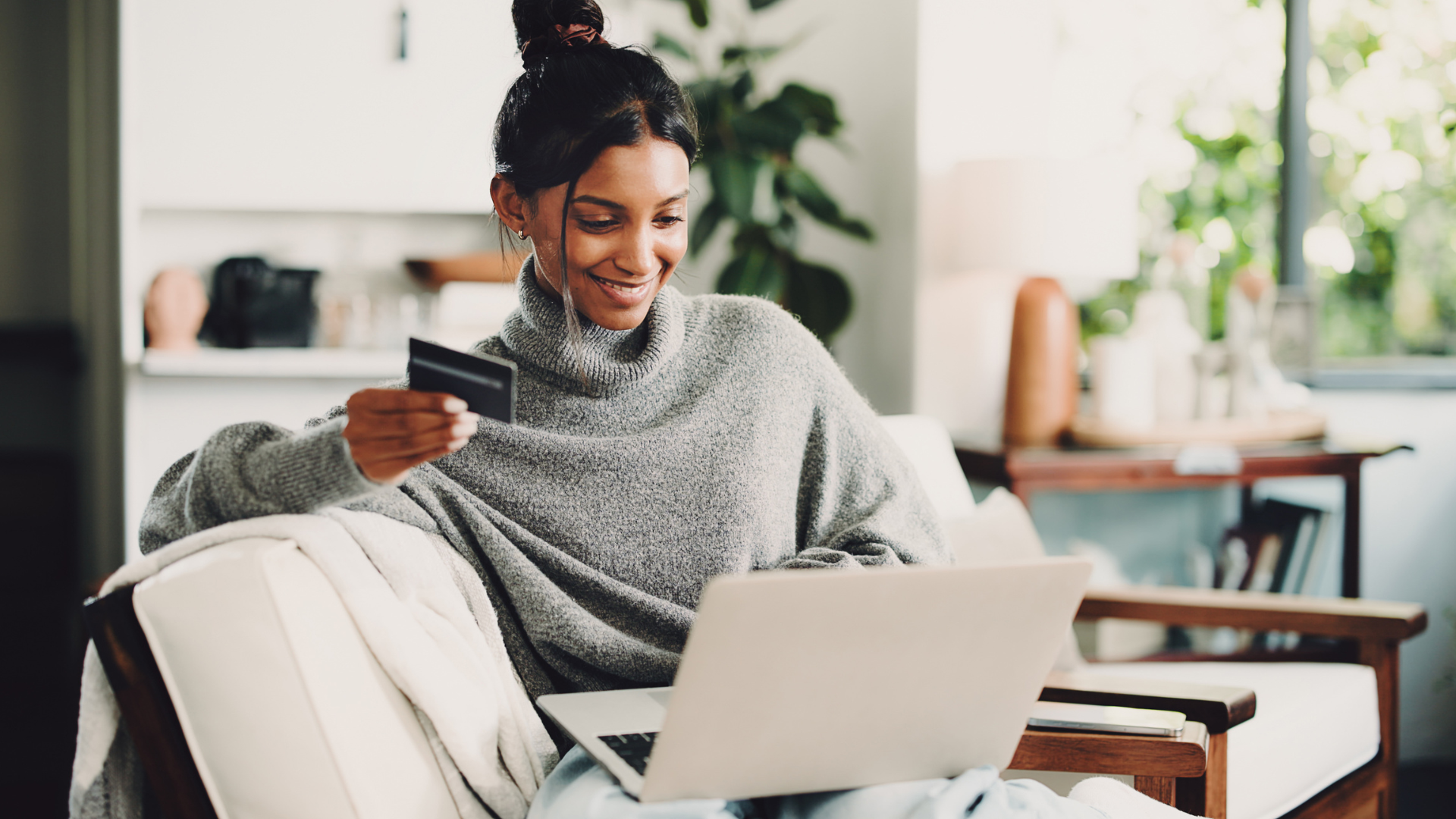 Home, laptop and woman on sofa, credit card and digital app for online banking.
